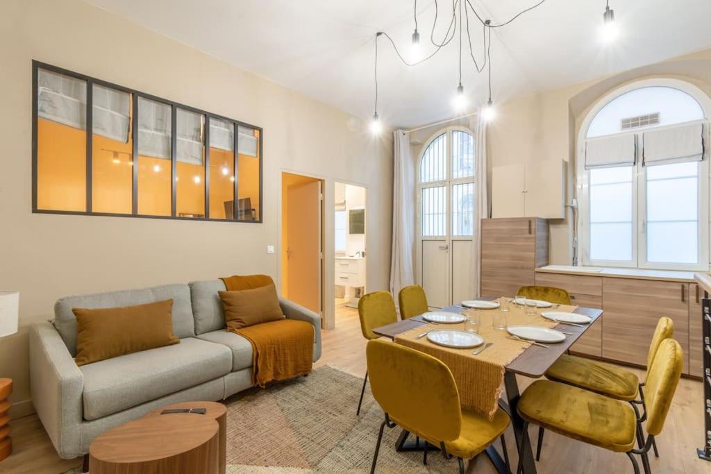 un salon avec un canapé, une table et des chaises dans l'établissement Nouveau - Designer Appartement - 6p, à Paris
