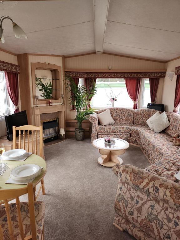 a living room with a couch and a table at The promenade, nr to fantasy island minimum 3 nights stay in Ingoldmells