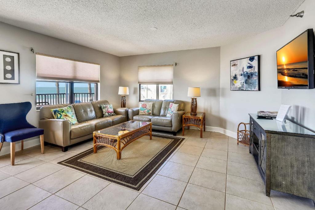 a living room with a couch and a tv at Emerald Isle 103 in St Pete Beach