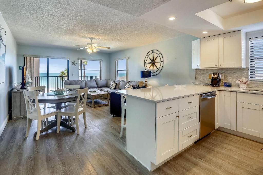 a kitchen and living room with a table and a couch at Emerald Isle 204 in St. Pete Beach