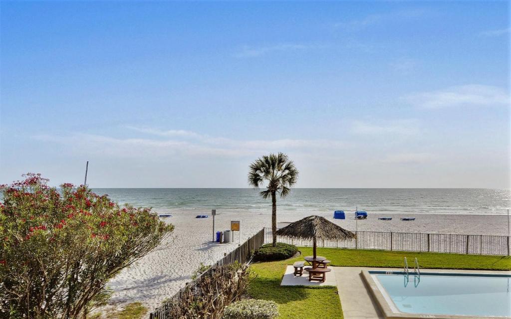 a view of the beach with a swimming pool and the ocean at Emerald Isle 101 in St Pete Beach