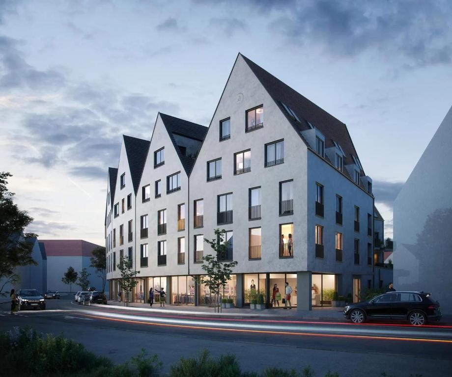 a large white building with a black roof at Businessapartment Metzingen Wilhelmstraße in Metzingen