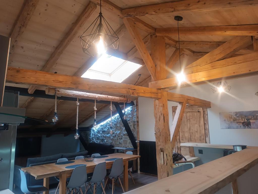 ein Esszimmer mit Tischen, Stühlen und einem Fenster in der Unterkunft Les étoiles de Bevy Gîtes in Lajoux
