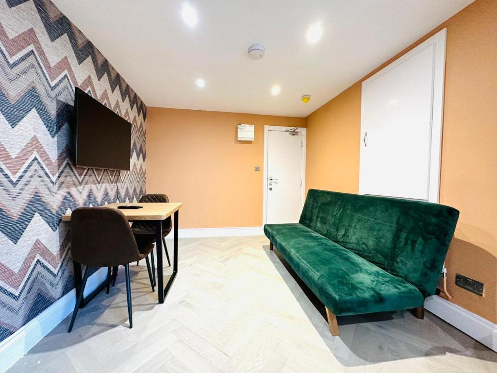 sala de estar con sofá verde y mesa en MODERN ONE BEDROOM NEAR STATION SLP3, en Brighton & Hove