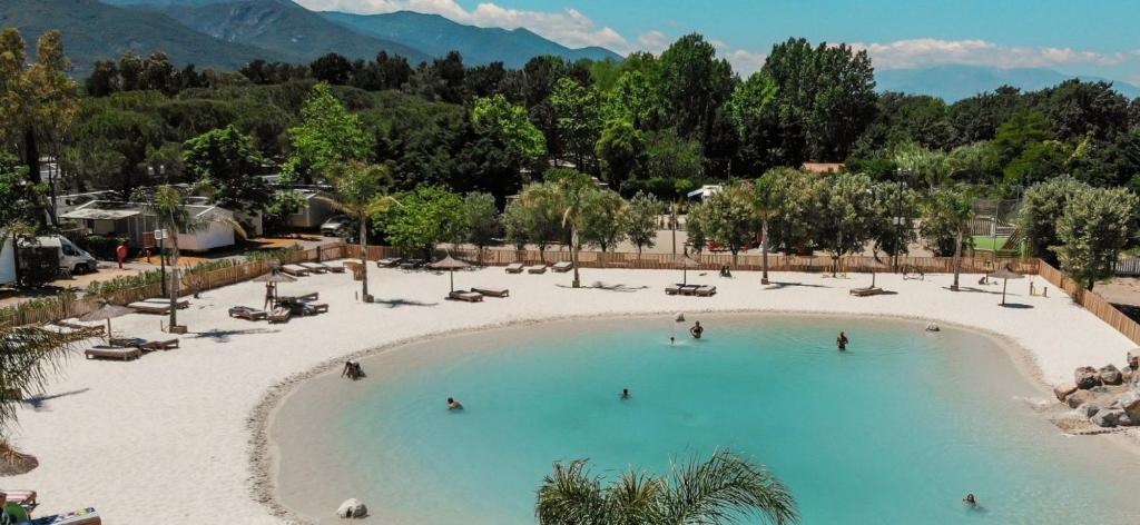 a large swimming pool with people in the water at Oh! Campings - La Tamarissière Agde in Agde