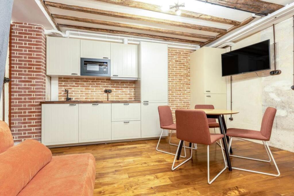 - un salon avec une cuisine et une table avec des chaises dans l'établissement NOUVEAU - Loft industriel - 4pp, à Paris