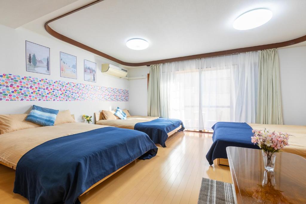 a hotel room with two beds and a table at Shinjuku Yotsuya House in Tokyo