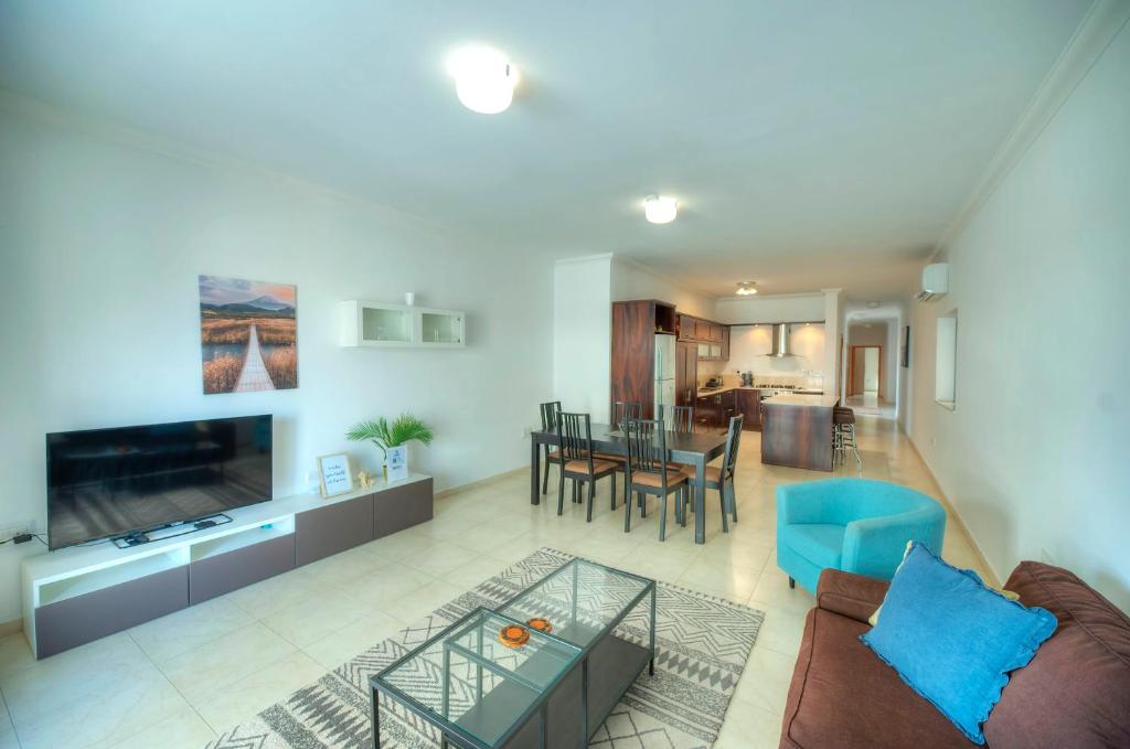 Modern 3BR Stylish & Spacious Apartment - Close to Sliema Promenade في إيل جزيرا: غرفة معيشة مع أريكة وطاولة