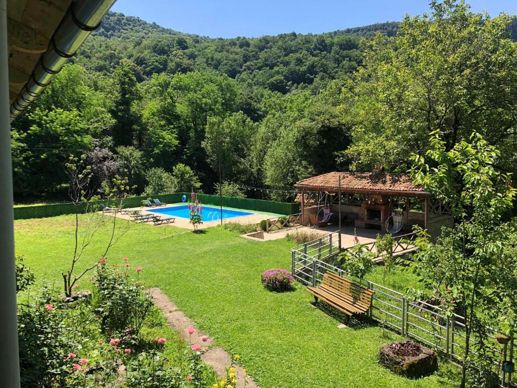 a garden with a swimming pool and a gazebo at Villa Kursebi in Kutaisi