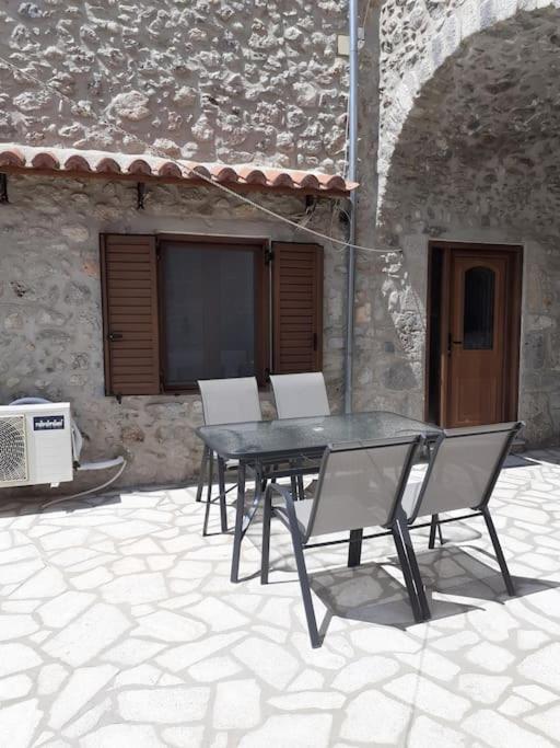 una mesa y sillas frente a un edificio en klisounis house, en Leonidio