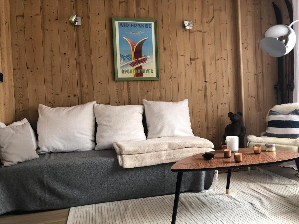 a living room with a couch and a table at Appartement 6 personnes aux 2 Alpes, au pied des pistes - Wi-fi, Parking gratuit, Terrasse vue sur jardin in Les Deux Alpes