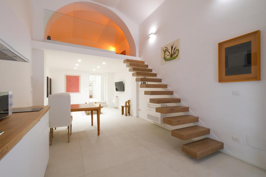 uma escada numa sala de estar com uma mesa e uma secretária em Old Stone House em Bari