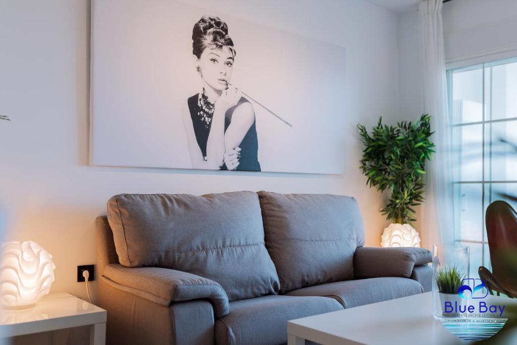 sala de estar con sofá y una foto en la pared en Breakfast at Tiffanys en La Herradura