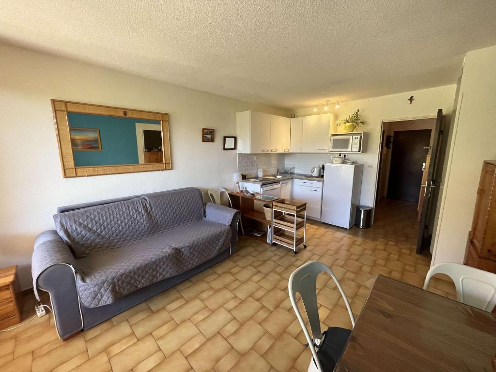 un salon avec un canapé et une cuisine dans l'établissement Studio confort avec piscine, à 30m de la mer, Cap d'Agde - FR-1-607-76, au Cap d'Agde
