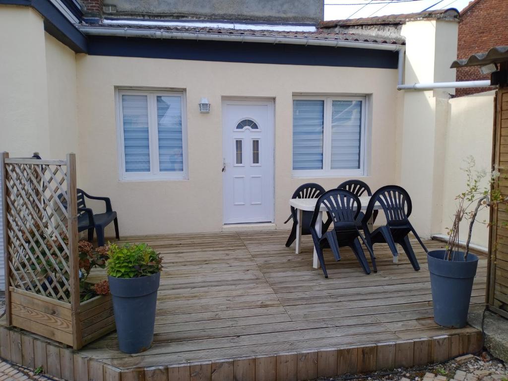 une terrasse en bois avec des chaises et une table sur une maison dans l'établissement Chambre studio, à Calais