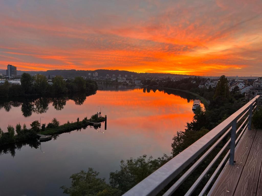 een uitzicht op een meer met een zonsondergang op de achtergrond bij Penthouse Wohnung mit schönem Moselblick in Metternich in Koblenz