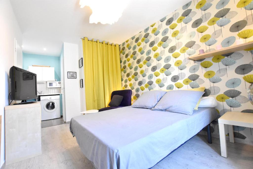 - une chambre avec un lit, une télévision et un mur dans l'établissement Coquet studio centre historique et au calme (4), à Montpellier