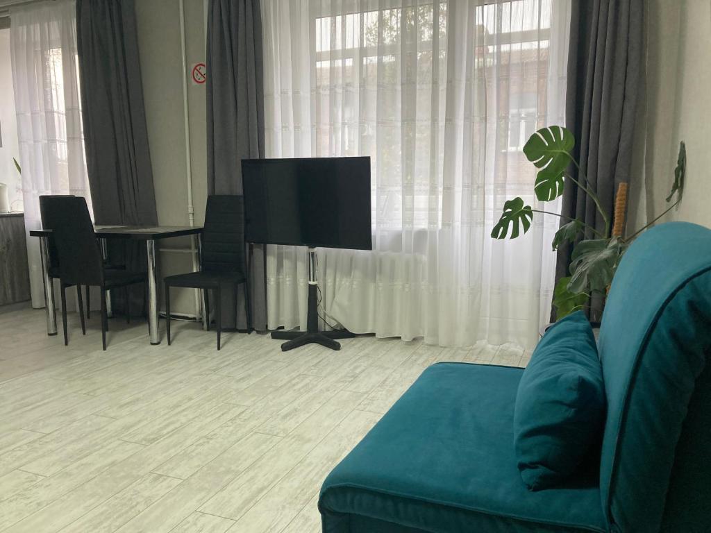 een woonkamer met een bank, een tv en een tafel bij Apartment Artynova 29 in Vinnytsya