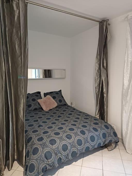 une chambre avec un lit avec une couette bleue et blanche dans l'établissement joli studio design balcon sud et parking gratuit, à La Garde