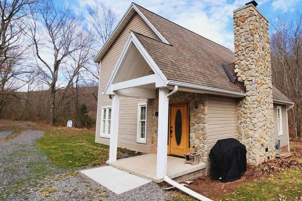 a small house with a front porch and a yellow door at Lane's End near Deep Creek Lake in Swanton