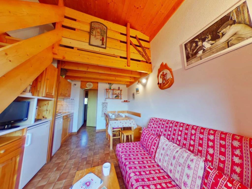 un salon avec un canapé rouge et une cuisine dans l'établissement Charmant Appartement Familial 2 Pièces avec Mezzanine, Balcon et Proximité des Pistes - Hauteluce - FR-1-594-93, à Hauteluce