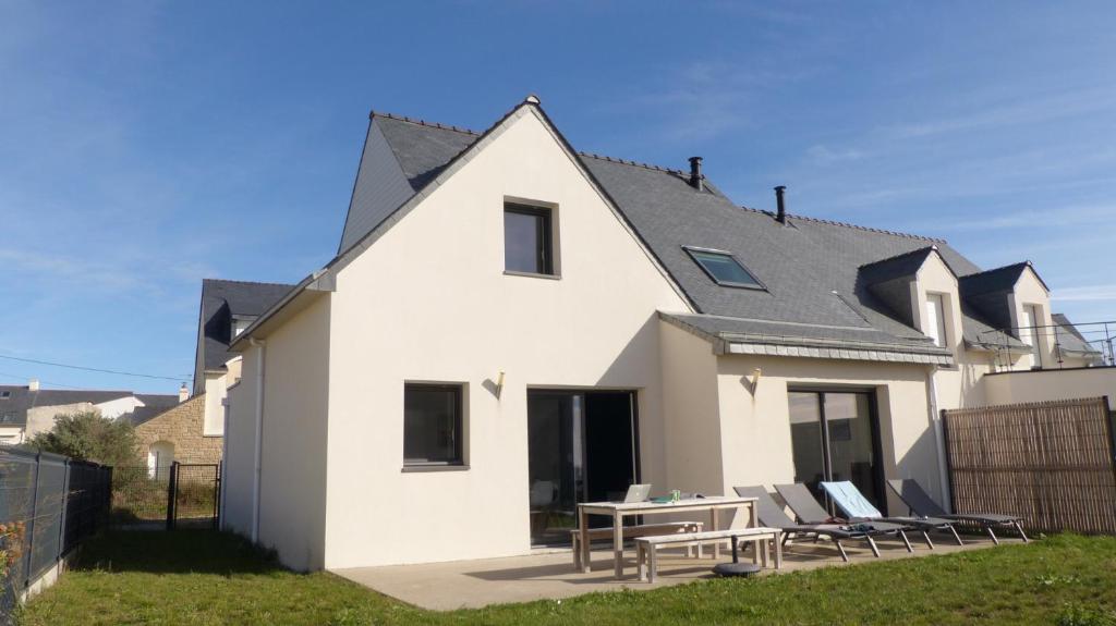 une maison blanche avec une table et des chaises dans l'établissement Maison tout confort en bord de mer à Quiberon, à Quiberon