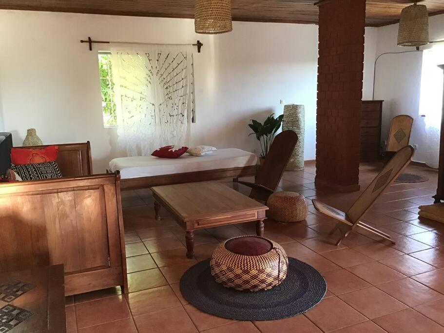 ein Wohnzimmer mit einem Bett und einem Tisch in der Unterkunft Villa Kanto - Belle maison et jolie vue Mga centre in Mahajanga