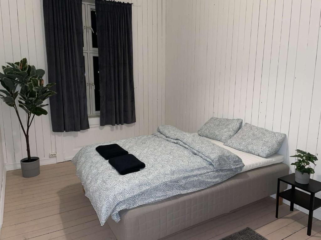 um quarto com uma cama com um cobertor e almofadas em Rom midt i Oslo sentrum - Gå avstand til det meste em Oslo