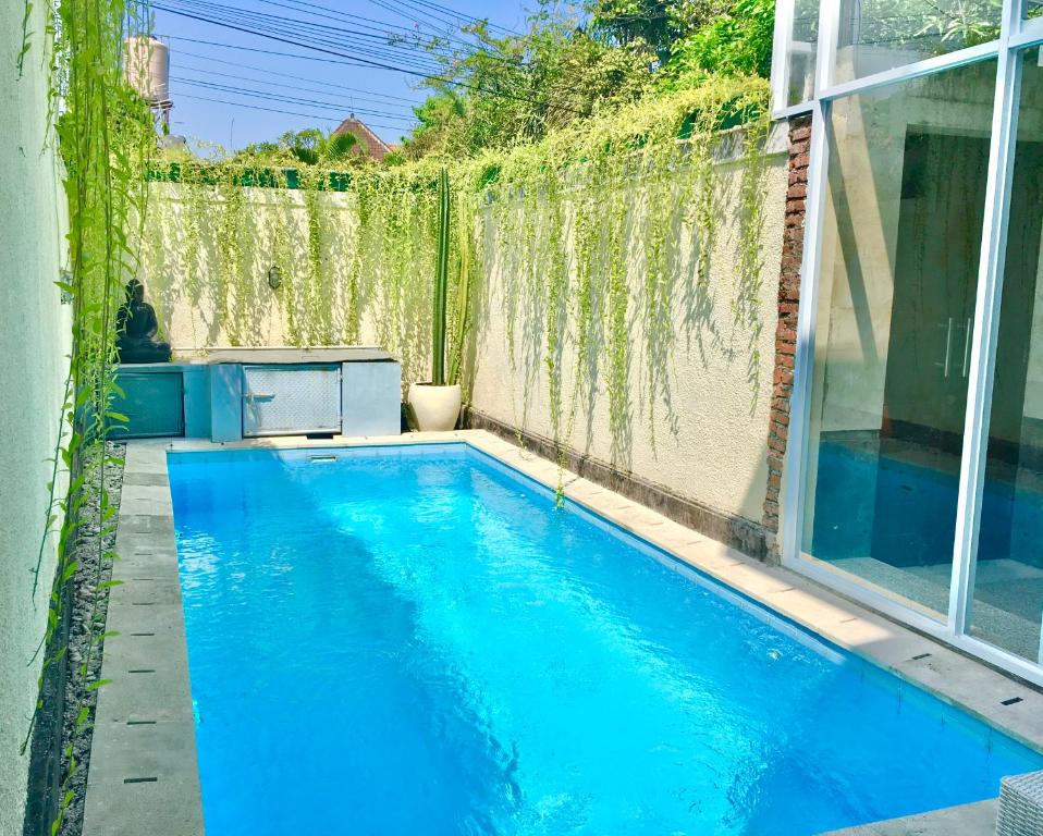 a swimming pool in the backyard of a house at Villa Jalak Kembar in Canggu