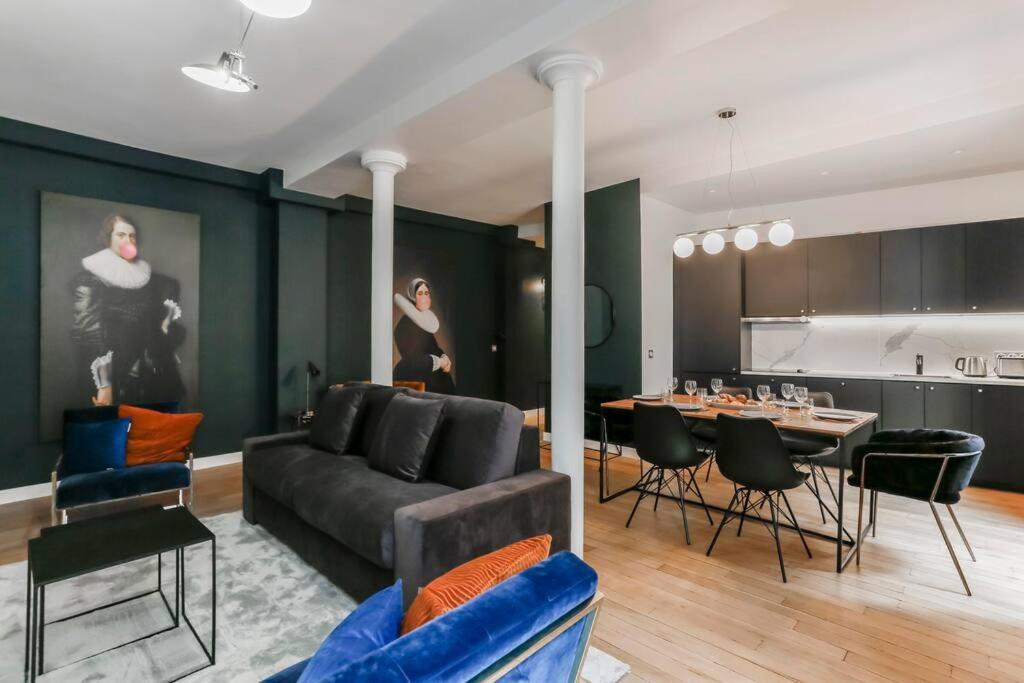 un salon avec un canapé et une table avec des chaises dans l'établissement Stylish 2 bedrooms Palais Royal, à Paris