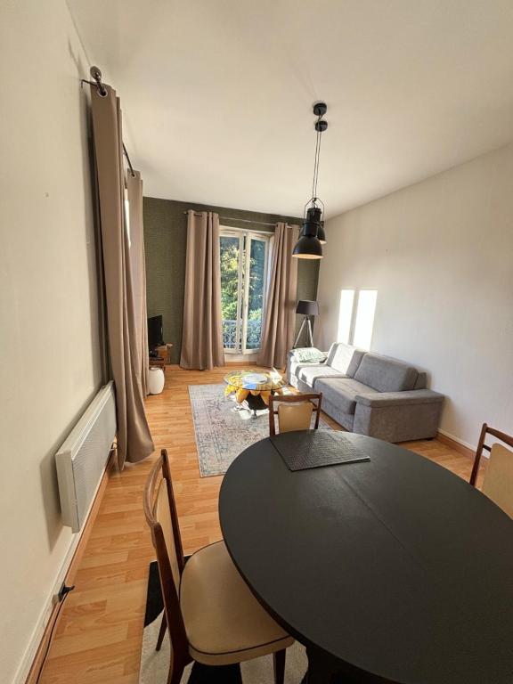 a living room with a table and a couch at ALINE GRAND HOTEL in Capvern