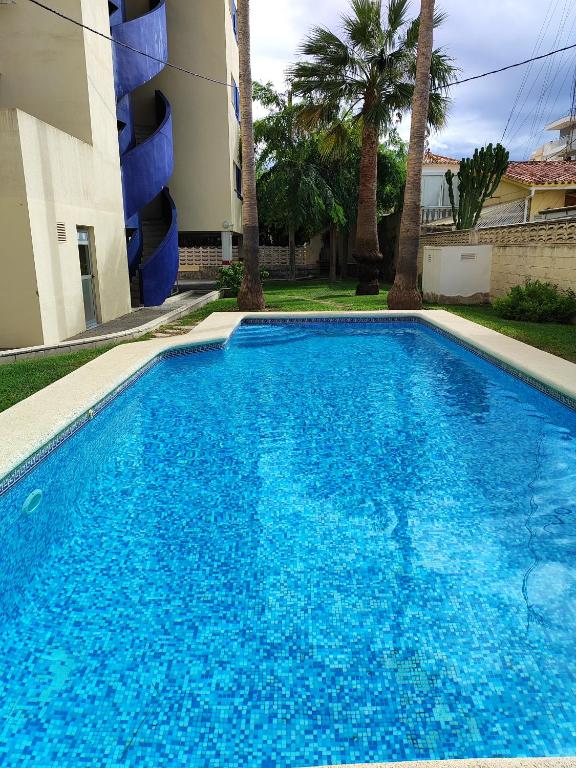 una gran piscina azul junto a un edificio en Apartamento Piles Playa, en Piles