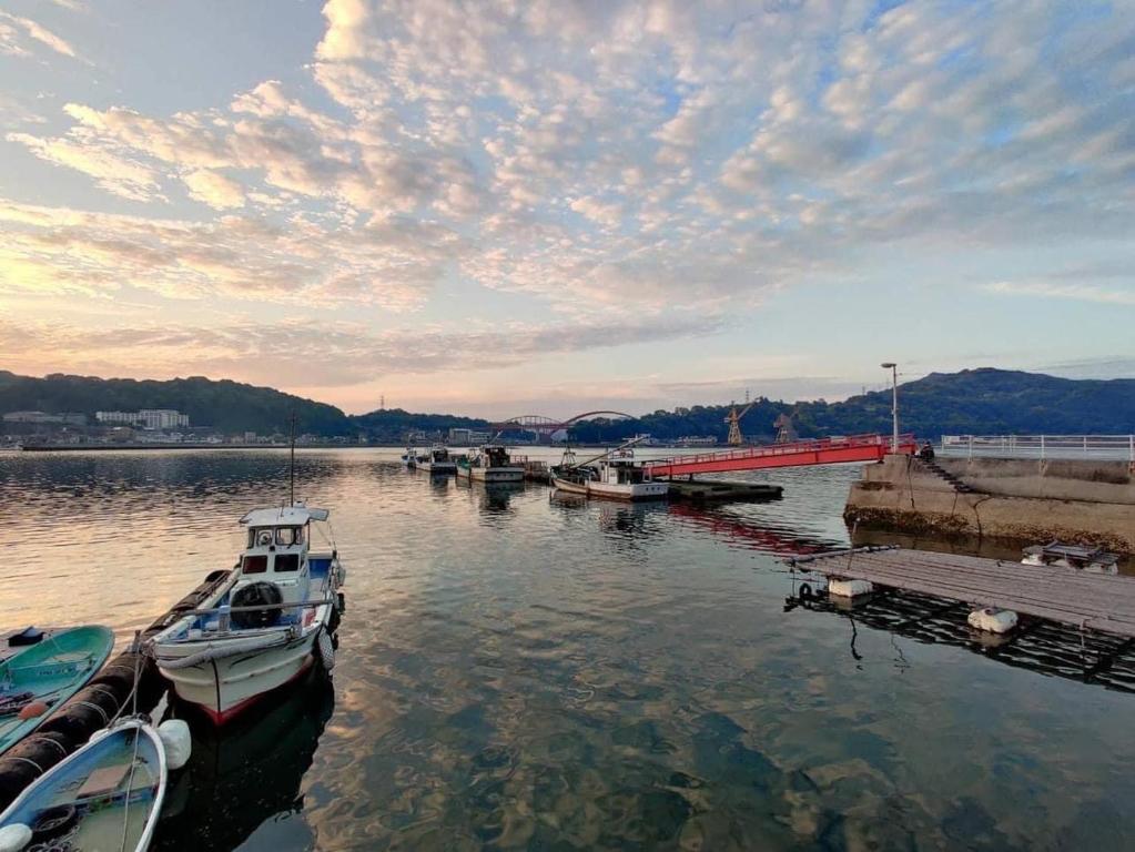 a boat is docked at a dock in the water at Guesthouse SETOUCHI LIFE in Kure