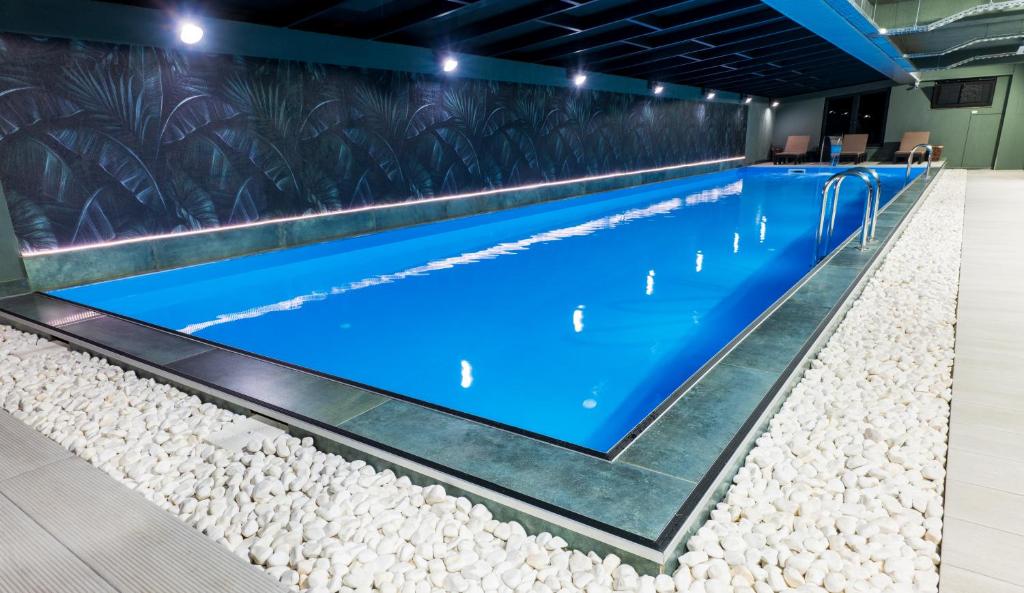 a large swimming pool with rocks around it at Jazz Hotel in Tbilisi City