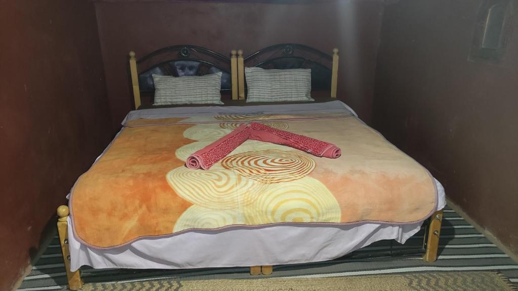 a bed with two red handles on it at Camp & Trek in Mhamid