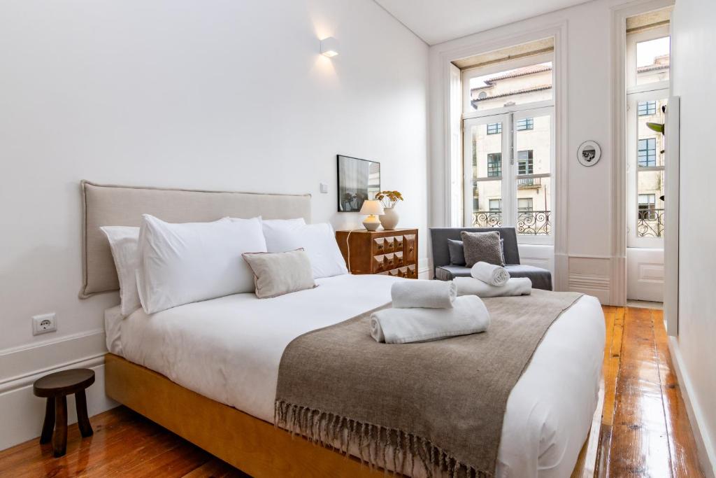 biała sypialnia z dużym łóżkiem i krzesłem w obiekcie Studio Sta w Porto