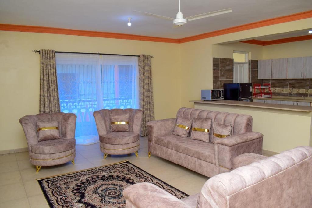ein Wohnzimmer mit 2 Sofas und 2 Stühlen in der Unterkunft Millan Homes in Mombasa