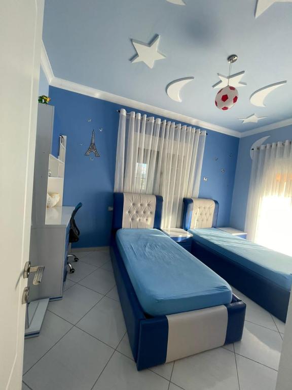 Habitación azul con 2 camas y escritorio. en Dervishi’s apartment, 
