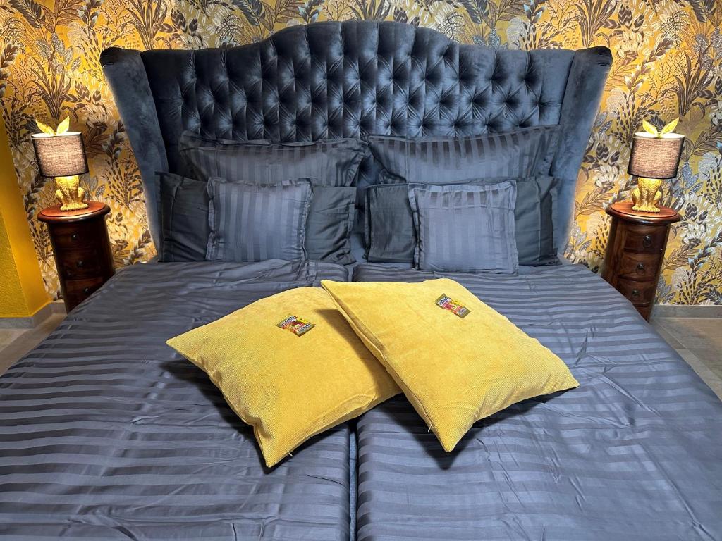 Una cama azul con dos almohadas amarillas. en Palais -MehrGehtNicht-Maisonette, en Großweitzschen
