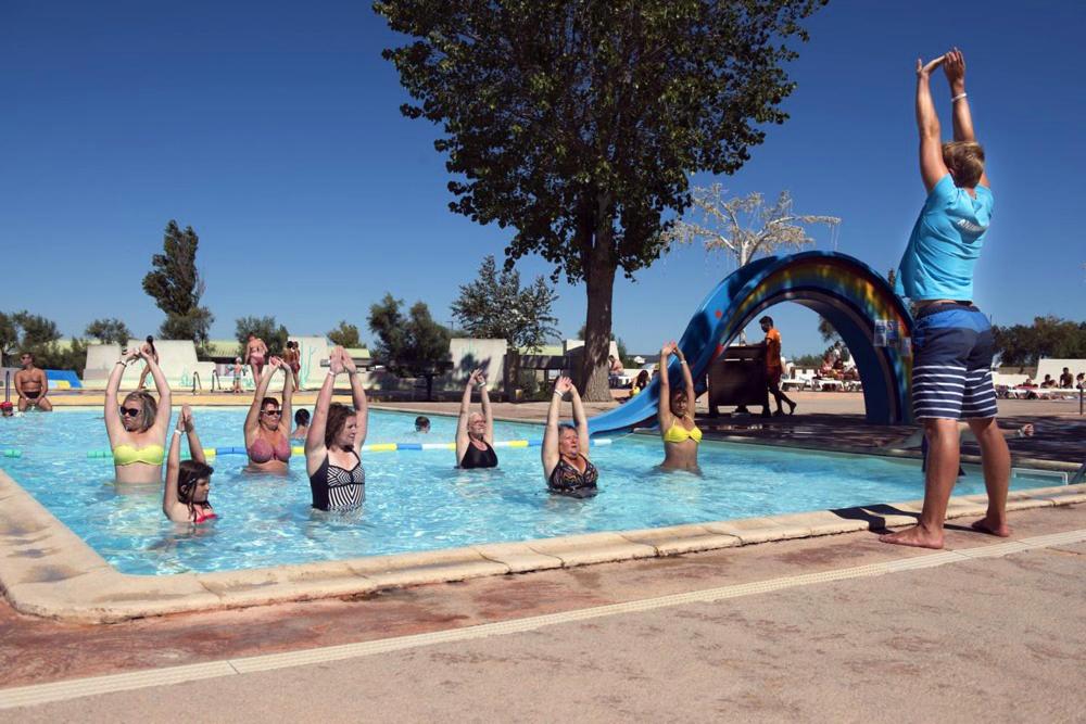 un grupo de personas haciendo yoga en una piscina en Oh! Camping - Les Roquilles Palavas les Flots, en Palavas-les-Flots