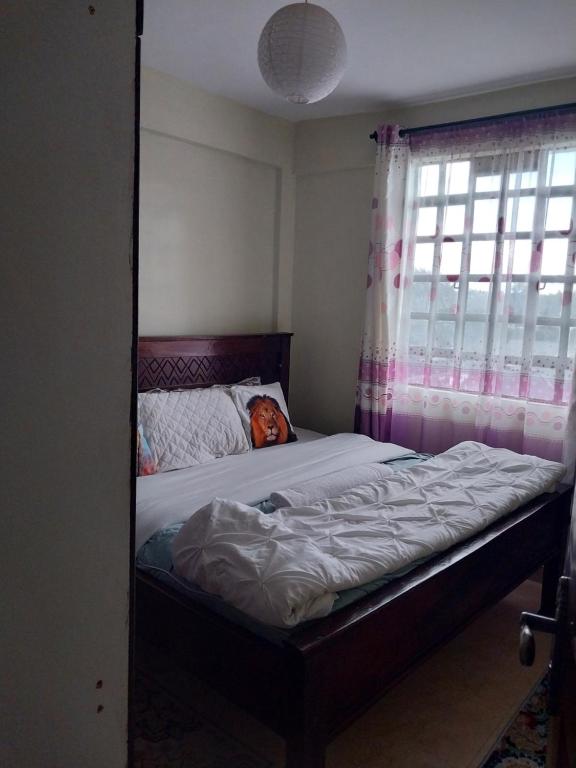 un letto con un cane steso su di esso in una camera da letto di Nova suite a Eldoret
