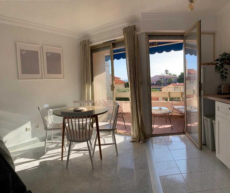 a kitchen and dining room with a table and chairs at Appartement LUNA - lumineux, vue mer, à 50m de la plage, climatisé et parking inclus in Cagnes-sur-Mer