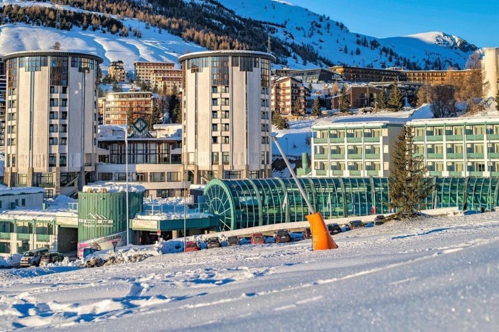 una città nella neve con edifici e una montagna di villaggio olimpico a Sestriere