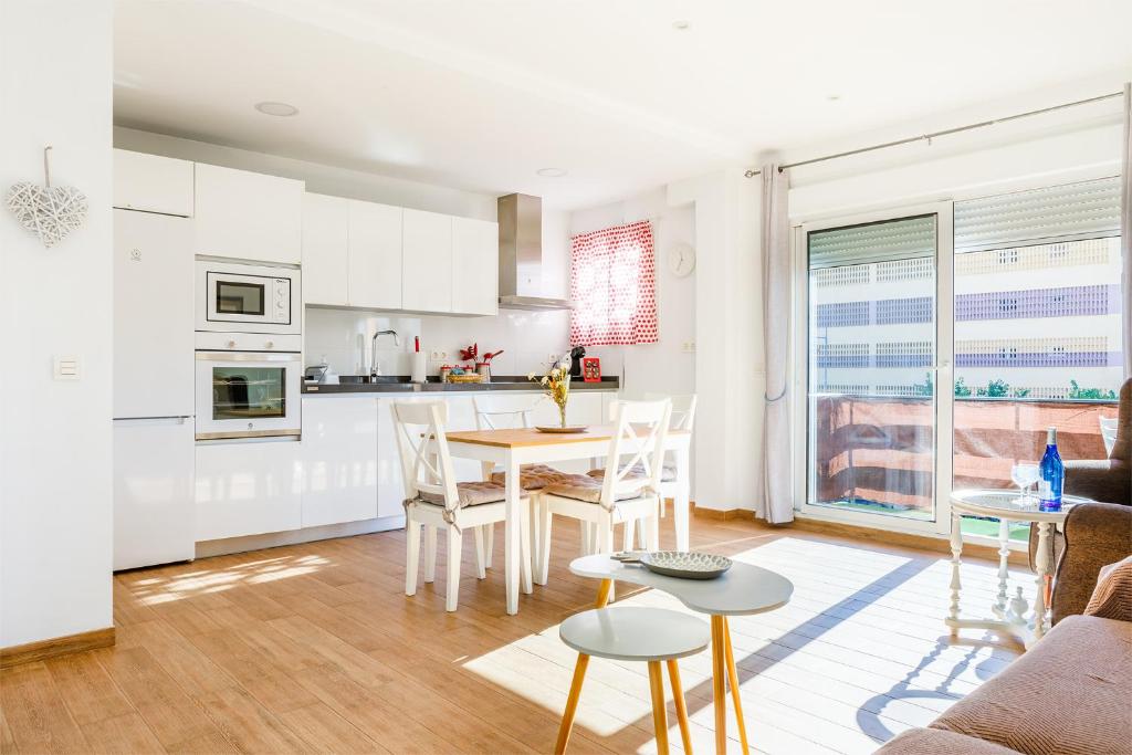 Il comprend une cuisine et un salon avec une table et des chaises. dans l'établissement Apartamento IRMASOL, à Torre del Mar