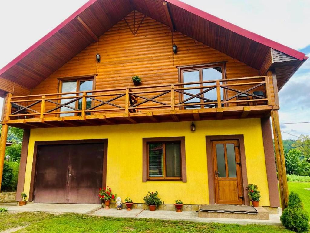 a yellow house with a balcony on top of it at Садиба Орхідея Шешори in Sheshory