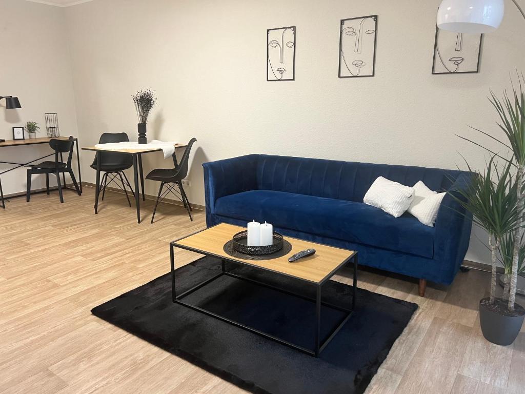 sala de estar con sofá azul y mesa en Charming Homes - Studio 10, en Wolfsburg