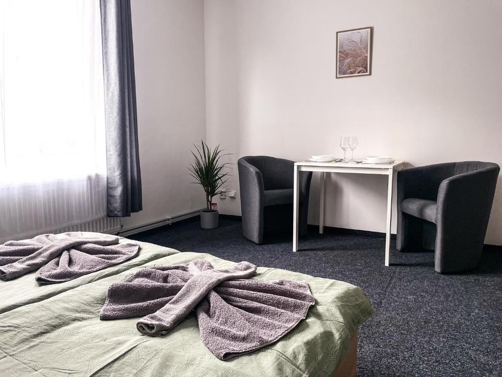 a hotel room with a bed and a table and chairs at Apartmány Plzeň Zborovská 22 a in Plzeň