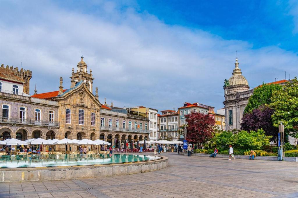 a city square with a fountain in front of a building at Historic House in Braga