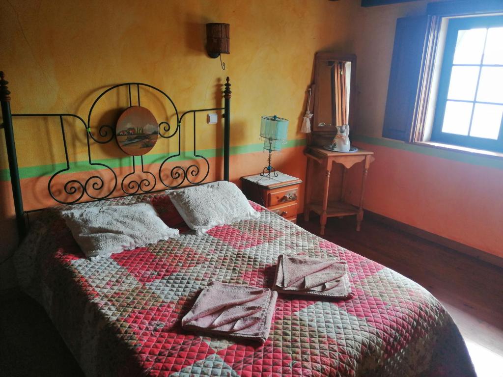 1 dormitorio con 1 cama grande y 2 almohadas en Golf & Surf Holiday House, en Casal da Lagoa Seca