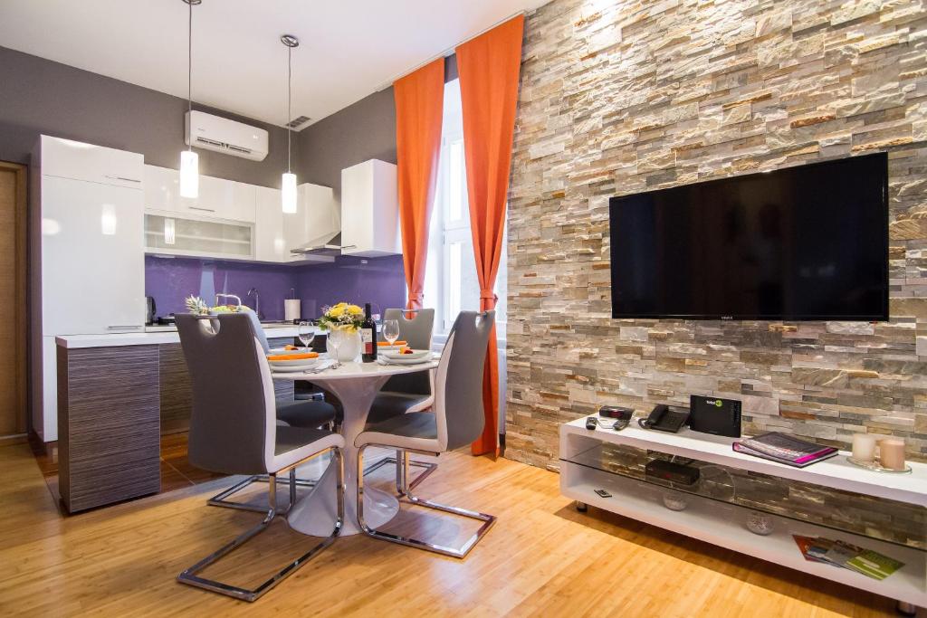 uma cozinha e sala de jantar com uma mesa e uma televisão em VisitZagreb Apartment em Zagreb